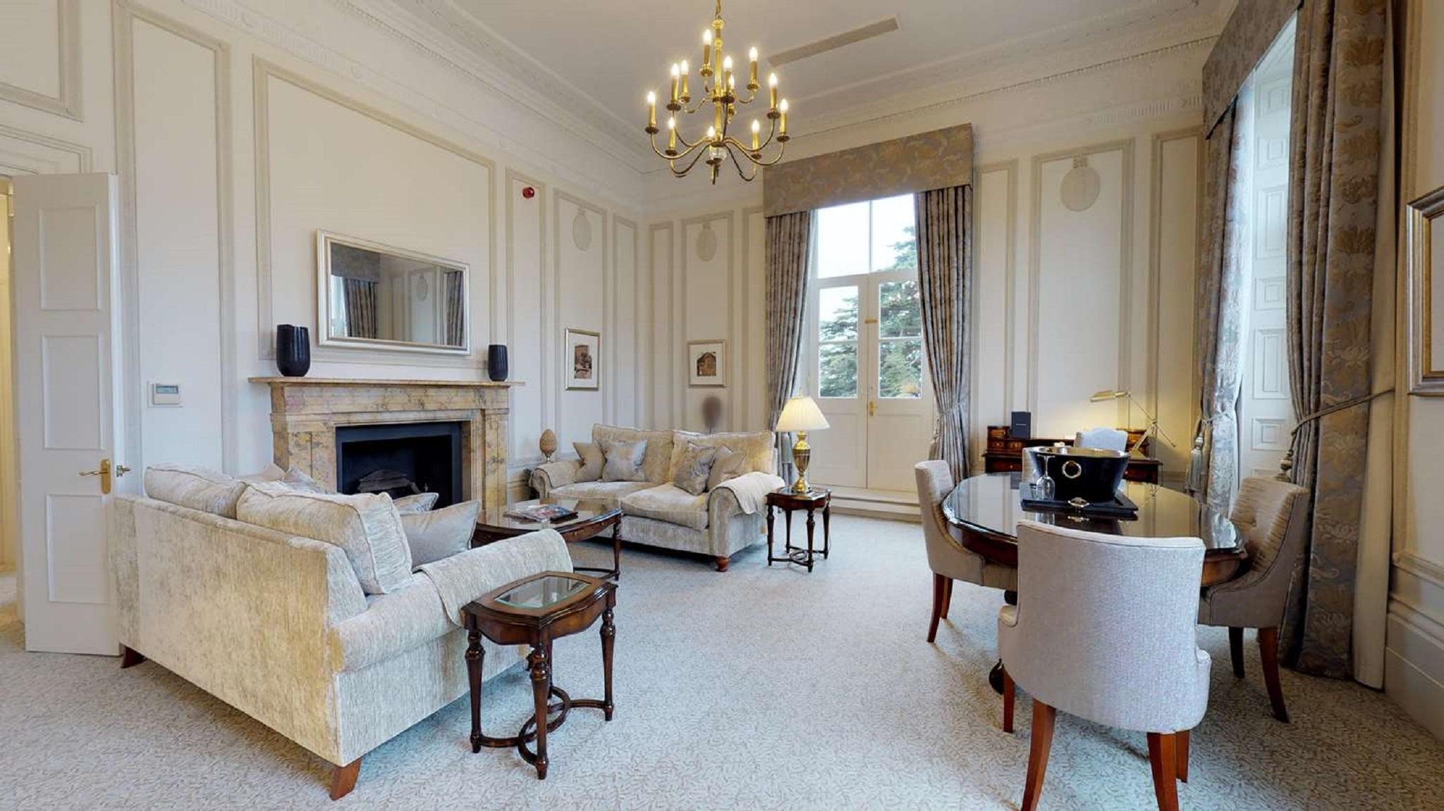 Macdonald Bath Spa Hotel Kültér fotó The photo shows an elegant living room with a classic design. It features a large chandelier hanging from the ceiling, providing soft lighting. The walls are adorned with decorative moldings and have a light color. 

In the center, there are two plus