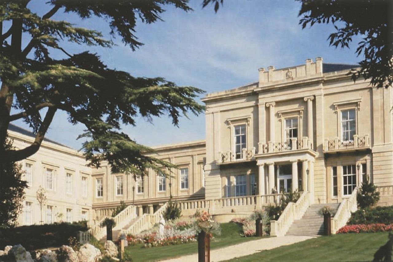 Macdonald Bath Spa Hotel Kültér fotó The photo depicts an elegant, stately building characterized by classical architecture. It features a symmetrical facade with large windows and decorative balconies. The structure is complemented by a lush green lawn and landscaped gardens, enhancing